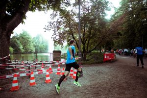 Läufer in blauer Sportkleidung beim Rennen entlang eines Parks.