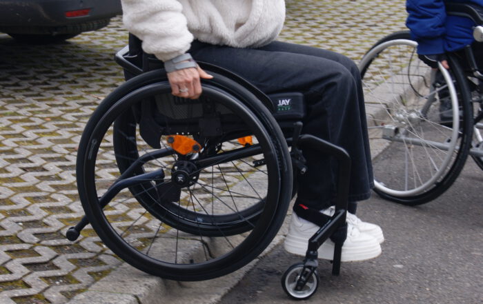 Rollifahrerin fährt an einen Bordstein