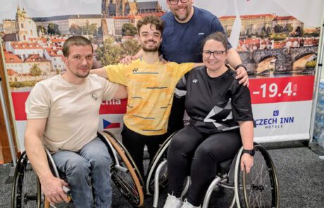csm_260427_Foto_privat_7a466d7d92 badminton (1) Vier Para-Badminton-Spielerinnen und -Spieler der Rhinos vor dem offiziellen Turnier-Banner Czech Para Badminton International 2026 in Prag, zwei davon im Sportrollstuhl