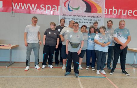 Mannschaftsfoto von Para-Boccia-Sportlerinnen und -Sportlern vor einem Banner des Deutschen Behindertensportverbandes