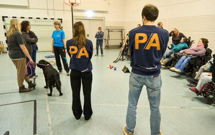Mitarbeitende der Firma Public Adress schauen beim Boccia zu. Auf em Rücken ihrer T-Shirts sieht man in großen Buchstaben PA