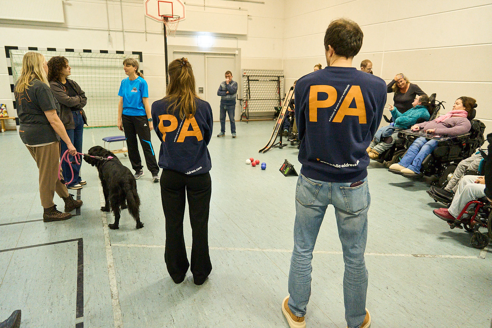 Mitarbeitende der Firma Public Adress schauen beim Boccia zu. Auf em Rücken ihrer T-Shirts sieht man in großen Buchstaben PA