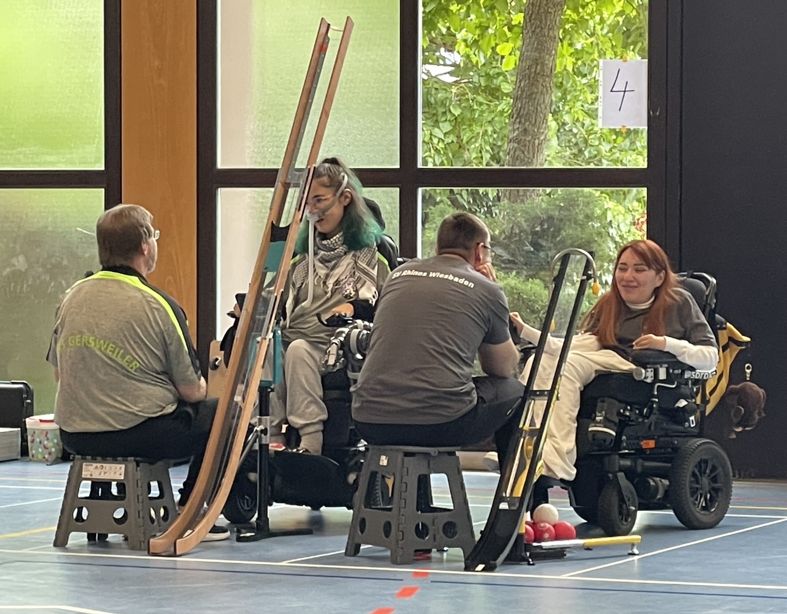 Iryna Soroka (SV Rhinos) im Rollstuhl beim ersten Turnier in Bad Kreuznach, Assistenz hilft beim Aufbau der Rampe.
